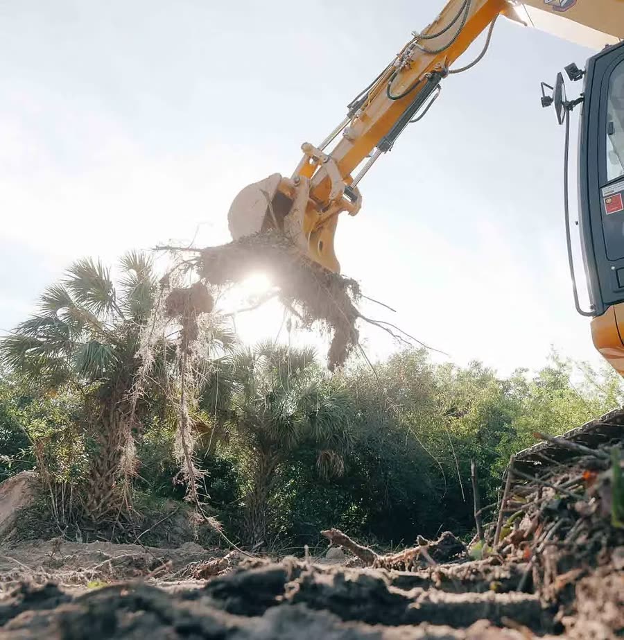 Bradberry Land Management excavator pulling roots on a Florida clearing job